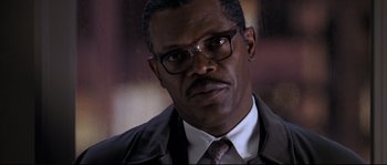 Movie still from “Changing Lanes” (2002), directed by Roger Michell – A person wearing a suit and glasses; Close Up shot, Low angle