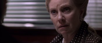 Movie still from “Changing Lanes” (2002), directed by Roger Michell – An older woman looking sad while sitting in a chair; Close Up shot, Over the shoulder angle