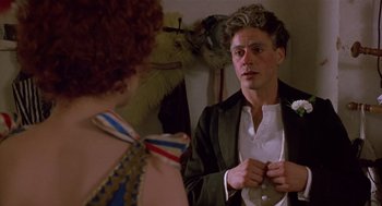 Movie still from “Chaplin” (1992), directed by Richard Attenborough – A man in a suit is looking at a woman in a white dress; Close Up shot, Over the shoulder angle