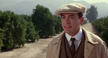 Movie still from “Chaplin” (1992), directed by Richard Attenborough – A man wearing a hat and a suit; Close Up shot, Over the shoulder angle