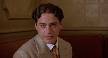 Movie still from “Chaplin” (1992), directed by Richard Attenborough – A person wearing a suit and tie; Close Up shot, Over the shoulder angle