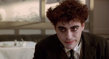 Movie still from “Chaplin” (1992), directed by Richard Attenborough – A person wearing a suit and tie; Close Up shot, Over the shoulder angle