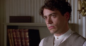 Movie still from “Chaplin” (1992), directed by Richard Attenborough – A person wearing a suit and tie; Close Up shot, Over the shoulder angle