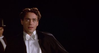 Movie still from “Chaplin” (1992), directed by Richard Attenborough – A person wearing a suit and bow tie; Close Up shot, Low angle