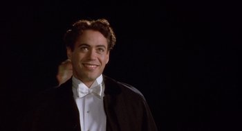 Movie still from “Chaplin” (1992), directed by Richard Attenborough – A person wearing a suit and bow tie; Close Up shot, Over the shoulder angle