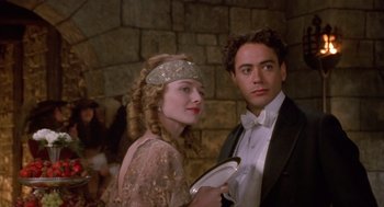 Movie still from “Chaplin” (1992), directed by Richard Attenborough – A man and a woman standing next to each other in front of a stone wall; Close Up shot, Over the shoulder angle