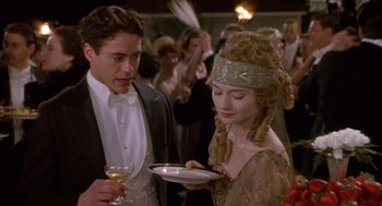 Movie still from “Chaplin” (1992), directed by Richard Attenborough – A man and a woman holding a plate in front of each other; Medium shot, Over the shoulder angle