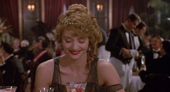 Movie still from “Chaplin” (1992), directed by Richard Attenborough – A woman in a black dress and a gold tiara; Close Up shot, Over the shoulder angle