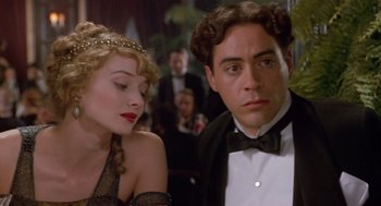 Movie still from “Chaplin” (1992), directed by Richard Attenborough – A man and a woman sitting next to each other in formal wear; Close Up shot, Over the shoulder angle