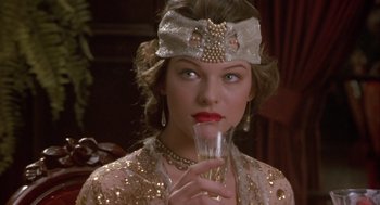Movie still from “Chaplin” (1992), directed by Richard Attenborough – A woman in a sequined dress holding a glass of wine; Close Up shot, Over the shoulder angle