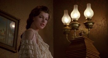 Movie still from “Chaplin” (1992), directed by Richard Attenborough – A woman in a white dress standing in front of a table; Medium shot, Low angle