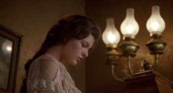 Movie still from “Chaplin” (1992), directed by Richard Attenborough – A young woman is sitting down and looking down; Close Up shot, High angle