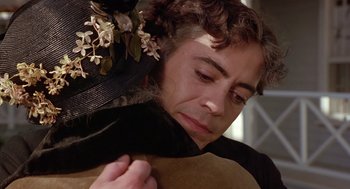 Movie still from “Chaplin” (1992), directed by Richard Attenborough – A woman in a black dress and a flower in her hair; Close Up shot, Over the shoulder angle