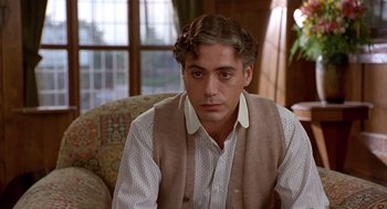 Movie still from “Chaplin” (1992), directed by Richard Attenborough – A person sitting on a couch; Close Up shot, Over the shoulder angle