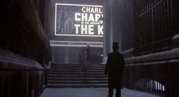 Movie still from “Chaplin” (1992), directed by Richard Attenborough – A man standing in front of a movie screen; Extreme Wide shot, Over the shoulder angle