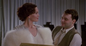 Movie still from “Chaplin” (1992), directed by Richard Attenborough – A man and a woman are standing next to each other; Medium shot, Over the shoulder angle