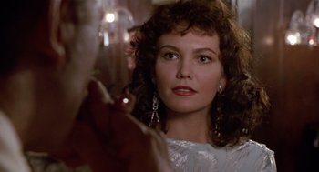 Movie still from “Chaplin” (1992), directed by Richard Attenborough – A person holding a glass of wine; Close Up shot, Over the shoulder angle