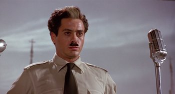 Movie still from “Chaplin” (1992), directed by Richard Attenborough – A person wearing a shirt and tie; Close Up shot, Low angle