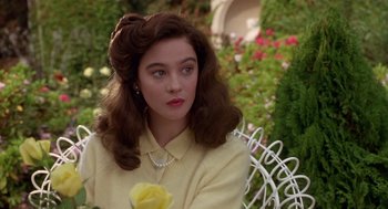 Movie still from “Chaplin” (1992), directed by Richard Attenborough – A woman with a yellow shirt holding a yellow rose; Close Up shot, Over the shoulder angle