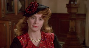 Movie still from “Chaplin” (1992), directed by Richard Attenborough – A person wearing a hat and a necklace; Close Up shot, Over the shoulder angle