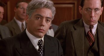 Movie still from “Chaplin” (1992), directed by Richard Attenborough – A person wearing a suit and a tie; Close Up shot, Over the shoulder angle