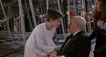 Movie still from “Chaplin” (1992), directed by Richard Attenborough – A man and a woman in formal wear talking to each other; Medium shot, Over the shoulder angle