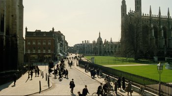 Movie still from “Chariots of Fire” (1981), directed by Hugh Hudson – A group of people riding bikes down a street; Extreme Wide shot, High angle