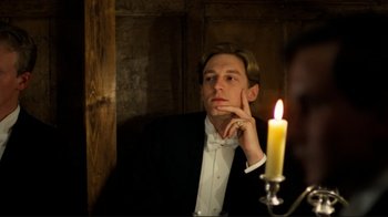 Movie still from “Chariots of Fire” (1981), directed by Hugh Hudson – A man in a tuxedo sitting in front of a lit candle; Close Up shot, Low angle