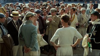 Movie still from “Chariots of Fire” (1981), directed by Hugh Hudson – A group of men standing next to each other in a crowd; Wide shot, High angle