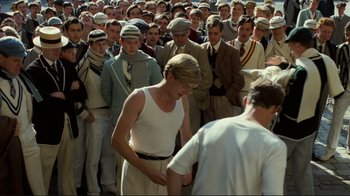 Movie still from “Chariots of Fire” (1981), directed by Hugh Hudson – A crowd of men and women standing in front of each other; Medium shot, Over the shoulder angle