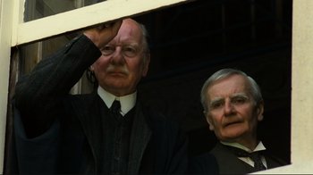 Movie still from “Chariots of Fire” (1981), directed by Hugh Hudson – Two older men standing next to each other in front of a window; Close Up shot, Low angle