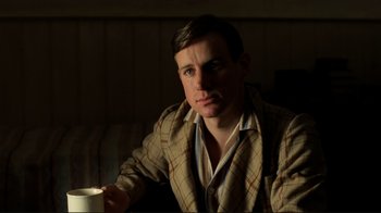 Movie still from “Chariots of Fire” (1981), directed by Hugh Hudson – A man sitting in front of a window holding a coffee cup; Close Up shot, Low angle