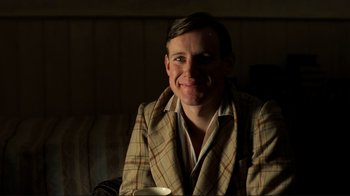 Movie still from “Chariots of Fire” (1981), directed by Hugh Hudson – A man in a plaid jacket holding a coffee cup; Close Up shot, Low angle