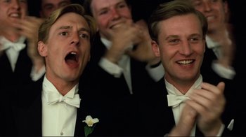 Movie still from “Chariots of Fire” (1981), directed by Hugh Hudson – A group of men in tuxedos and bow ties; Close Up shot, Low angle