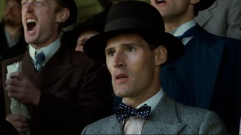 Movie still from “Chariots of Fire” (1981), directed by Hugh Hudson – A man wearing a hat and a bow tie in front of a crowd; Close Up shot, Low angle