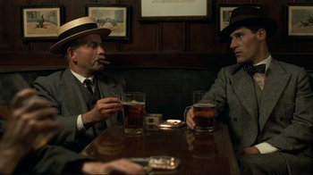 Movie still from “Chariots of Fire” (1981), directed by Hugh Hudson – A group of men sitting at a table with drinks; Medium shot, Over the shoulder angle