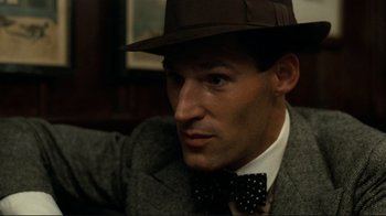 Movie still from “Chariots of Fire” (1981), directed by Hugh Hudson – A man wearing a hat and a bow tie; Close Up shot, High angle