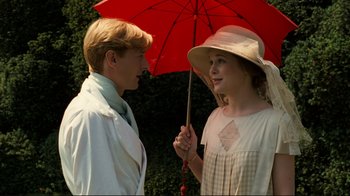 Movie still from “Chariots of Fire” (1981), directed by Hugh Hudson – A man and a woman standing under a red umbrella; Medium shot, Low angle