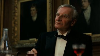 Movie still from “Chariots of Fire” (1981), directed by Hugh Hudson – An older man in a tuxedo holding a glass of wine; Close Up shot, Over the shoulder angle
