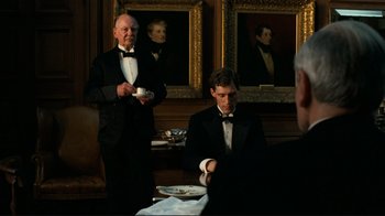 Two men in tuxedos sitting at a dinner table