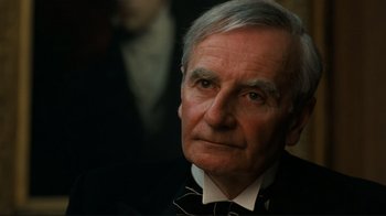 Movie still from “Chariots of Fire” (1981), directed by Hugh Hudson – An older man wearing a black suit and a bow tie; Close Up shot, High angle