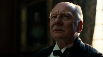 An older man in a suit and tie looking up