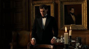 Movie still from “Chariots of Fire” (1981), directed by Hugh Hudson – A man in a tuxedo standing in front of a candle; Medium shot, Low angle