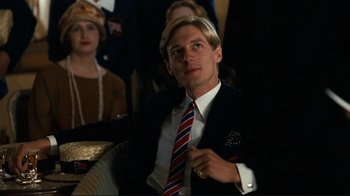 Movie still from “Chariots of Fire” (1981), directed by Hugh Hudson – A man in a suit and tie sitting next to a woman; Close Up shot, Low angle