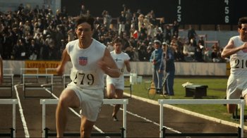Movie still from “Chariots of Fire” (1981), directed by Hugh Hudson – A man running in a track and field event; Medium shot, Over the shoulder angle