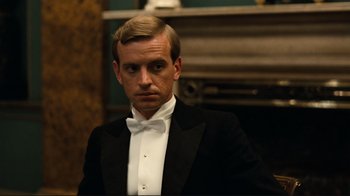 Movie still from “Chariots of Fire” (1981), directed by Hugh Hudson – A man in a tuxedo is standing in front of a fire place; Close Up shot, Low angle