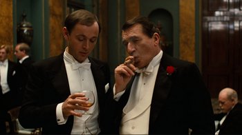 Movie still from “Chariots of Fire” (1981), directed by Hugh Hudson – Two men in tuxedos are smoking and drinking; Medium shot, Low angle