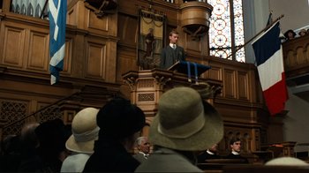 Movie still from “Chariots of Fire” (1981), directed by Hugh Hudson – A man is giving a speech in front of a group of people; Wide shot, Low angle