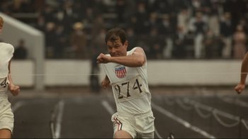 Movie still from “Chariots of Fire” (1981), directed by Hugh Hudson – A man in white shirt and shorts swinging a tennis racquet; Medium shot, High angle
