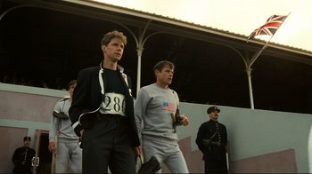 Movie still from “Chariots of Fire” (1981), directed by Hugh Hudson – A group of men standing next to each other on a field; Medium shot, Low angle